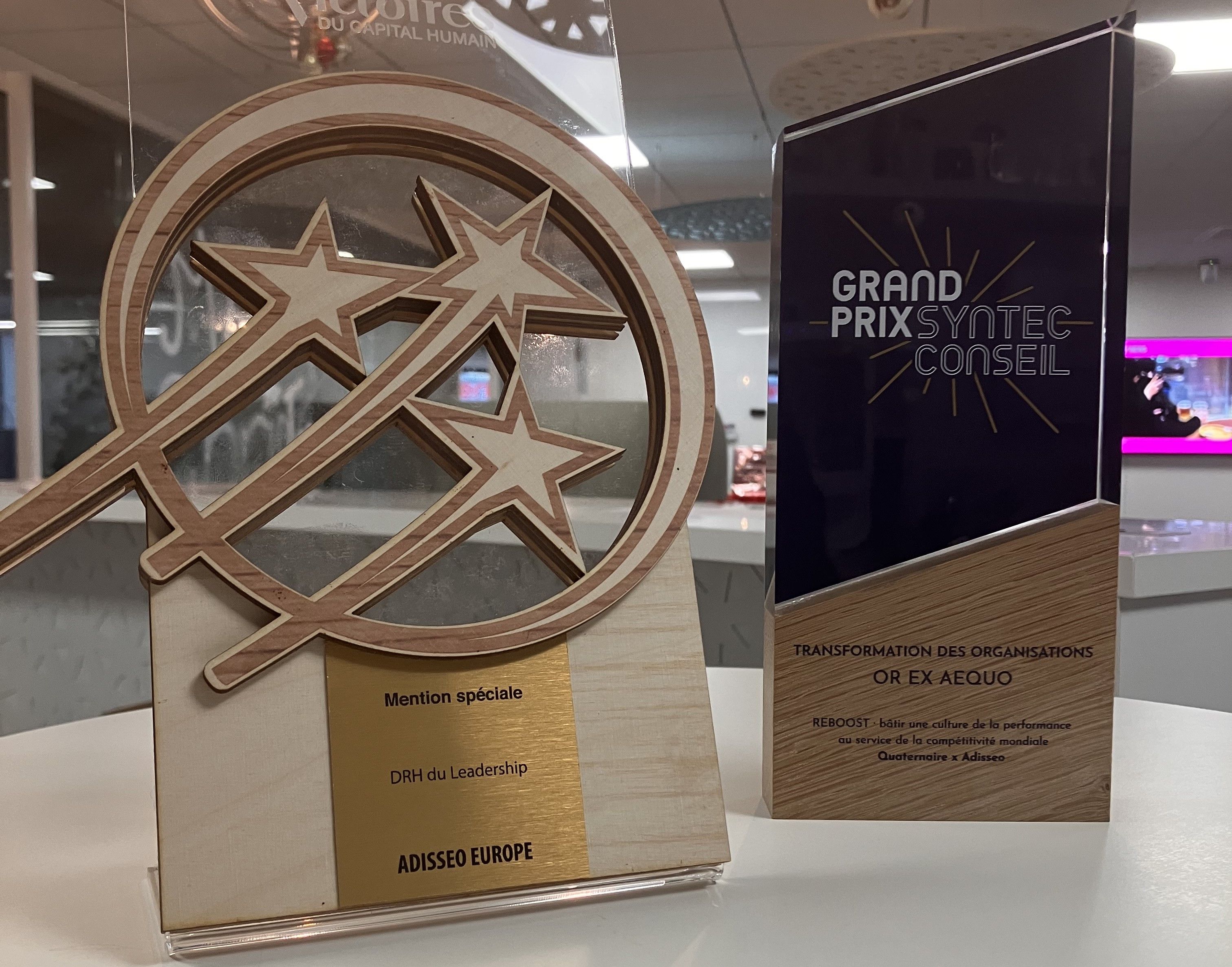 两座奖杯陈列在桌上：一座是镶嵌星徽的木质奖杯，另一座则是长方形奖牌。